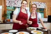 Veronika Ams (r.), und ihre Tochter Katharina richten die Hauptspeise an.