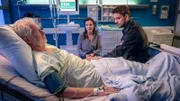 Kris (Marc Barthel, r.) und seine Mutter (Oda Thormeyer, M.) bangen um seinen Vater (Komparse, l.), der einen Schlaganfall erlitten hat.