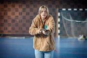 In einer Turnhalle h&auml;lt die Sch&uuml;lerin Nathalie (Vilda Schubert) ein Gewehr in der Hand.