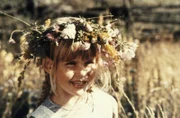 Ida (Lena Wisborg) amüsiert sich mit ihrem Blumenkranz auf dem Kopf und bemerkt, wie ruhig es plötzlich ohne Michel ist.
