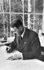 Adolf Hitler am Schreibtisch.
