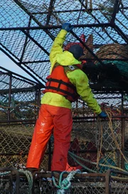 Wizard deckhand, Tyler Gateman guides another pot to the stack.