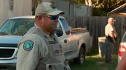 Game Warden standing next to vehicle.