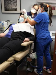 Dr. Lee ist gerade dabei, die Wucherung an der Seite von Debra Maxwells Kopf zu entfernen.