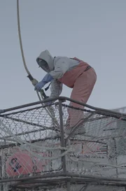 Wizard greenhorn, Caelan Colburn attaches a picking hook to a crab pot in the shipyard.