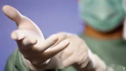 Surgeon Putting on Gloves --- Image by