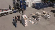 Kran im Einsatz für den Belastungscheck von Schwerlastregalen: Welches trägt eine Tonne?
