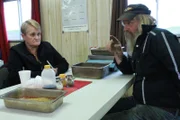 Tony Beets and Minnie Beets at the table weighing gold.
