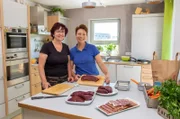 Bei den Vorbereitungen: Petra Rapp (re.) mit ihrer Freundin Sonja Lenz in der Küche mit den Zutaten ihres Gerichtes.
