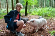 Tim (Noah Böhm) führt seine neuen Freunde im Wald spazieren.
