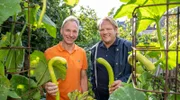 Björn Freitag (r) mit Herbert Budweg in seinem Hausgarten. Für das Menü nimmt Björn eine besondere Schlangenzucchini mit.