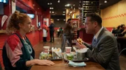 Mabel Kruse (Marleen Lohse, l.) sitzt nach dem Bewerbungsgespräch ihres Mannes Kevin Kruse (Aurel Manthei, r.) mit ihm im Burgerladen. Im Hintergrund steht der Filialleiter Mübariz Pettekaya (Kais Setti, 3.v.l.) und wartet auf die Polizei.