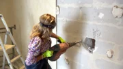 Carmen mit schwerem Gerät gegen die Mauer