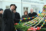 Schattenhofer (Werner Rom) begutachtet kritisch den Osterbrunnen.