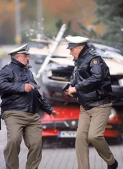 Herzberger (Dietmar Huhn, li.) und Bonrath (Gottfried Vollmer) können sich nur noch in Sicherheit bringen, als Grubers Wagen auf Bonraths neuem Alfa landet...