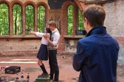 Felix (Valentino Fortuzzi, r.) filmt Till (Merlin Rose, M.) und Sophie (Emma Drogunova, l.) bei Schießübungen in der Kapellenruine.