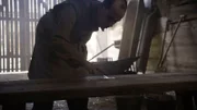 Ein Mann berührt eine Holzbank