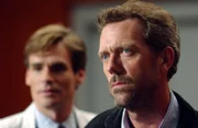 House (Hugh Laurie, r.) und Dr. Jack Wilson (Robert Sean Leonard) stellen nach eingehenden Untersuchungen bei der Patientin einen riesigen Lebertumor fest. Doch selbst die Entfernung des lebensbedrohlichen Geschwürs bringt die Symptome der Frau nicht zum Verschwinden. Die Ärzte stehen vor einem Rätsel.