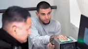 Der Verdächtige gibt einen Fingerabdruck ab.