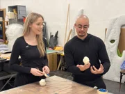 Lena und Puppenspieler Jo betrachten ihre selbstgebauten Fingerpuppen.