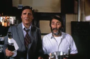 Josef Haslbeck (Helmut Fischer, links) preist sich mit Erfolg Giancarlo (Aurelio Ferrara) an - nur so kann er wieder einmal dem drohenden Rausschmiß von Ilse entgehen.