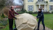 Der Untermieter der Reproduktionspraxis Frieder Wiesner (Stephan A. Tölle, l.) liebt seinen Garten mehr als alles andere. Jedoch kündigte ihm die Ehefrau des Opfers kurz vor dem Tod die Wohnung in der Praxis. Austauschpolizist Eddi Jansons (Gustavs Gailus, r.) hilft Herrn Wiesner, den Baum abzudecken, dem ihm damals seine verstorbene Frau zum Geburtstag pflanzte. Doch Buchhalter Wiesner scheint ein wenig zu gelassen für die Umstände.