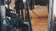 A forklift lifts a false bottom of a truck to have a huge load of methamphetamine and fentanyl. (National Geographic)