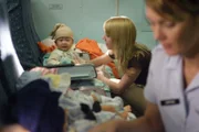 RE-ENACTMENT STILL:  The nurses help settle in the orphans