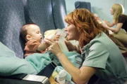 RE-ENACTMENT STILL: Nurse and baby ready for the flight.