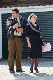 Siglinde Schwarzhuber (Cordula Trantow) und Riedl (Paul Sedlmeir) stehen vor ihrem Haus und warten auf Hubert und Staller, Yazid sowie Polizeirat Girwidz. Siglinde Schwarzhuber möchte ihren toten Hund Peppi beerdigen lassen. Dafür hat sie eigens einen Liedtext ausdrucken und an die Anwesenden verteilen lassen.