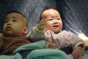 RE-ENACTMENT STILL:  Babies fussing in their seats.