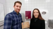 Katharina und Corvin, die beiden Gründer eines Start-ups aus Magdeburg, vor ihrem Periodenproduktspender.