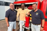 Wehrführer Hauke Scharf, Yared und Bürgermeister Karl Nagel.