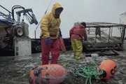 Northwestern deckhand Matt Bradley assists with dropping pots.