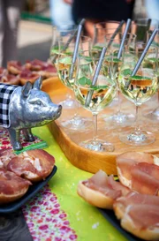 Sechs Landfrauen, ein Oldtimerbus und ein Kochwettbewerb mit jeweils einem Drei-Gänge-Menü. Weitere Informationen unter http://www.swr.de/lecker-aufs-land. Zur Begrüßung gibt es als Erfrischung einen Hugo sowie drei verschiedene Variationen vom hauseigenen geräucherten Schinken auf Brötchen.
