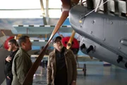 Adam Savage asks pilot Gary Yardley questions about the wooden propeller on the WWI fighter plane. (Jude Rushmore stands in background.)