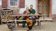 Sarah und Jorrit Alberts auf ihrem Hof am Dinnertisch. Das prachtvolle Federvieh ist auch neugierig.