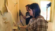 Ursula und Manuel entfernen die alte Tapete von der Wand