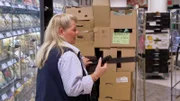 S02E42: Doris hat alle Hände voll zu tun: Ware einräumen, Brötchen schmieren, Bestellungen annehmen.