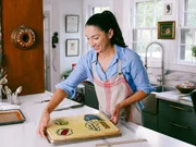 Gesine shows the final cake layer with icing stickers, as seen on Baked in Vermont, Season 1.