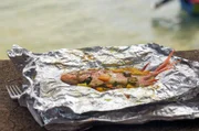 Portland, Jamaika: In einer feuerfesten Form bereitet Jérôme selbst gefangenen Fisch mit Gemüse und Gewürzen zu.