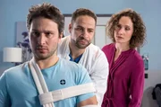 Dr. Matteo Moreau (Mike Adler, l.) untersucht den verunglückten Industriekletterer Oliver Weigand (Pablo Sprungala, l.). Er wundert sich, dass dieser so abweisend zu seiner Lebensgefährtin Jennifer  (Marie Ulbricht, r.) ist.