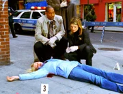 Eames (Kathryn Erbe) und Carver (Courtney B. Vance) nehmen die Leiche der von einem Strassenräuber erschossenen Frau in Augenschein.