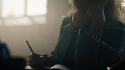 Die Frau telefoniert und macht sich Notizen