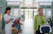 Lena Philips (Tanja Schleiff, re.) will ihre Schmerzen und ihr allgemeines Unwohlsein in der Sachsenklinik abklären lassen. Als sie von einer Schwester (Komparsin, li.) aufgerufen wird, bekommt die vielbeschäftigte Immobilienmaklerin das nicht annähernd mit.