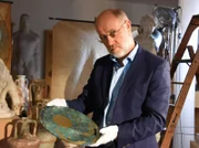 Harald Lesch mit einer Nachbildung der Nebra-Scheibe, die als früher Himmelskalender gilt.