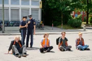 Polizist Wuttke (Daniel Donskoy, 3.v.l.) und seine Kollegin Strasser (Altine Emini, 2.v.l.) rufen Verstärkung. Alleine können sie die Protestierenden (von links: Joachim Seemann, Valerie Stoll, Adrian Grünewald, Maria Goletz) nicht vom Asphalt lösen. Doch die Straßen sind dicht und die Kollegen bei anderen Klimaprostestaktionen im Einsatz.