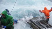 A big wave crashes over the rail onto the deck of the Northwestern.