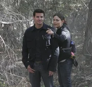 Booth (David Boreanaz, L) and Brennan (Emily Deschanel, R) find strange clues while investigating the murder of a student in the BONES episode "The Headless Witch in the Woods".