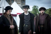 Thomas Cromwell (Mark Rylance) und sein Schutzbefohlener Rafe Sadler (Thomas Brodie-Sangster) erfahren von Cromwells Neffen Richard (Joss Porter, v.l.), dass der König bei einem Turnier angeblich tödlich verletzt wurde.